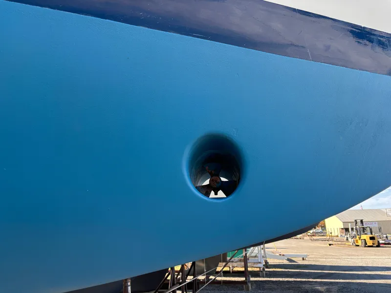 Slide: The Image of 1979 Hallberg-Rassy 38 sailboat hull with visible bow thruster in dry dock. - 17