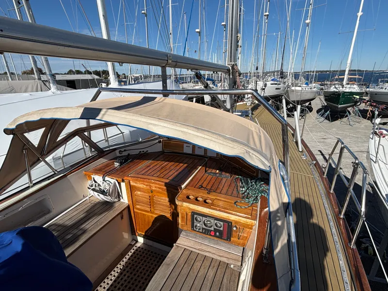 Slide: The Image of 1979 Hallberg-Rassy 38 sailboat cockpit with wooden details and canopy, docked at marina. - 23