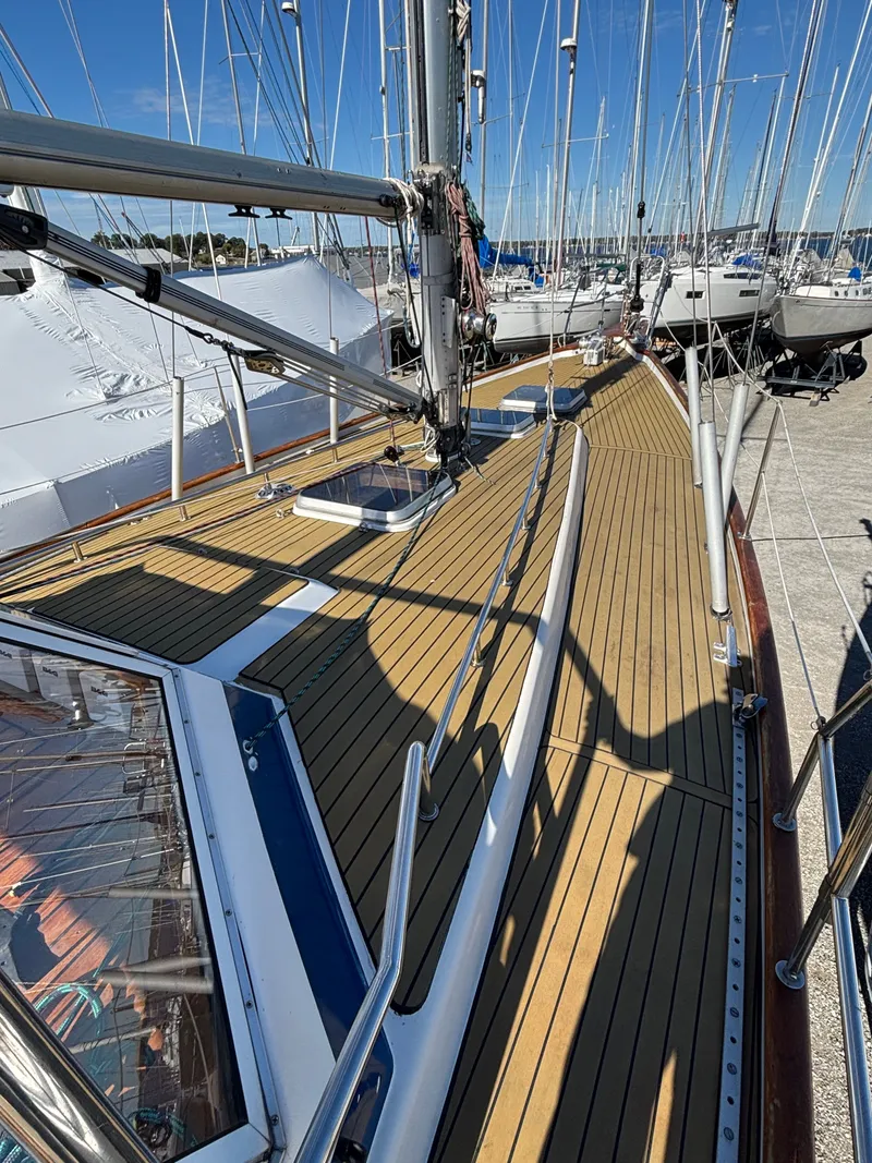 Slide: The Image of 1979 Hallberg-Rassy 38 sailboat deck with wooden finish and marina background. - 25