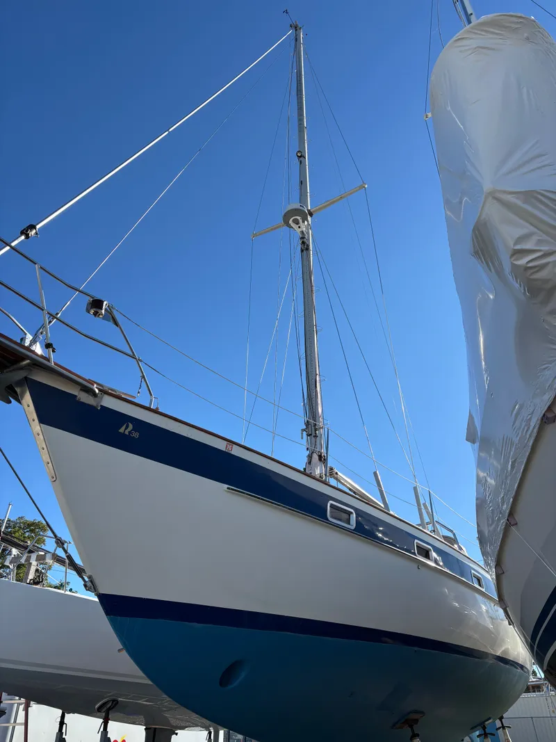 Slide: The Image of 1979 Hallberg-Rassy 38 sailboat with blue hull, docked under clear sky. - 3