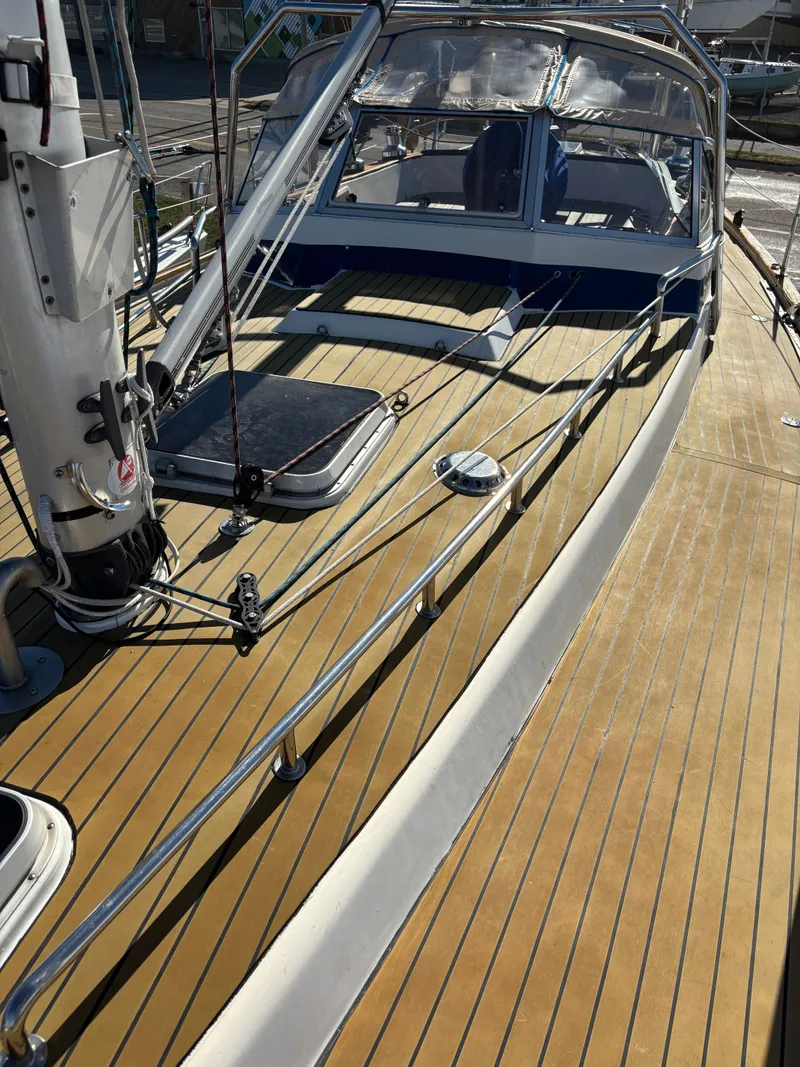 Slide: The Image of 1979 Hallberg-Rassy 38 sailboat deck with wooden finish and metal railings. - 36