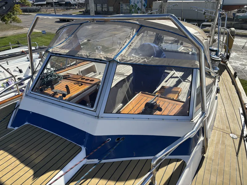 Slide: The Image of 1979 Hallberg-Rassy 38 sailboat with wooden deck and cockpit, featuring a protective canopy. - 40
