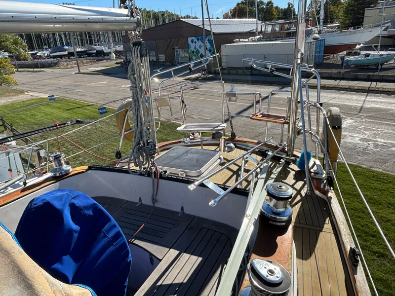 Slide: The Image of 1979 Hallberg-Rassy 38 sailboat deck with winches and rigging in a marina setting. - 42