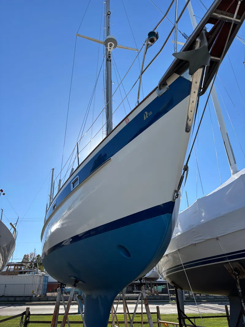 Slide: The Image of 1979 Hallberg-Rassy 38 sailboat on land, showcasing its sleek hull and mast. - 5