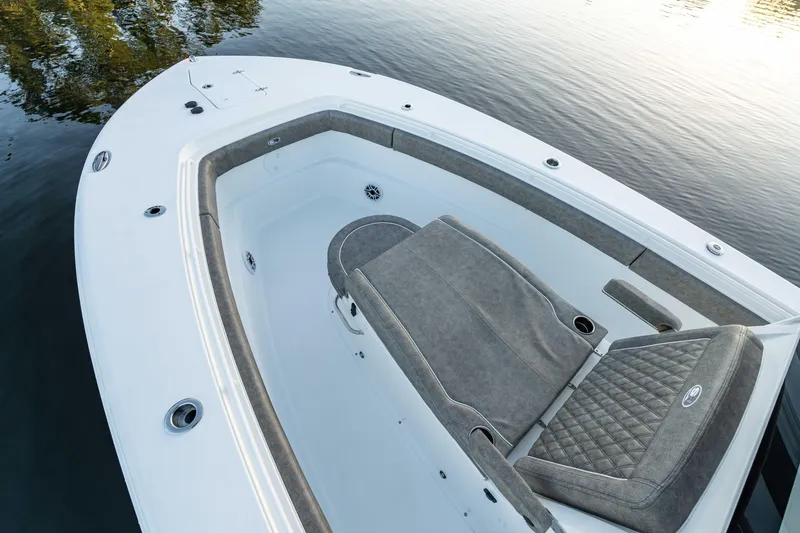 Slide: The Image of 2026 Sea Hunt Ultra 305 Coffin Box boat interior with cushioned seating on calm water. - 14