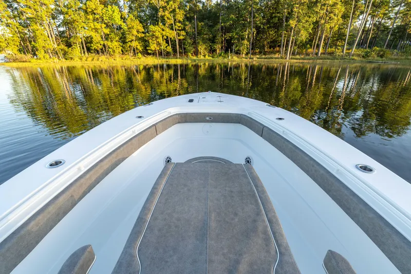 Slide: The Image of 2026 Sea Hunt Ultra 305 Coffin Box boat on calm lake with forest backdrop. - 17