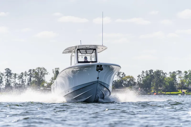 Slide: The Image of 2026 Sea Hunt Ultra 305 Coffin Box boat cruising on a sunny day. - 2