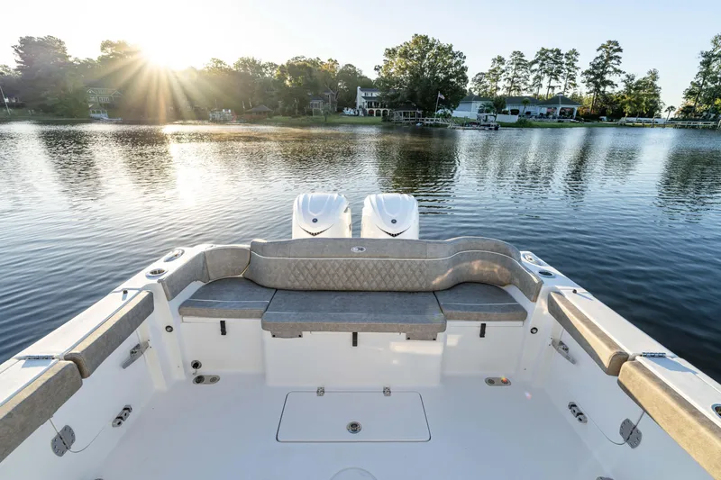 Slide: The Image of 2026 Sea Hunt Ultra 305 Coffin Box boat on serene lake at sunrise. - 22