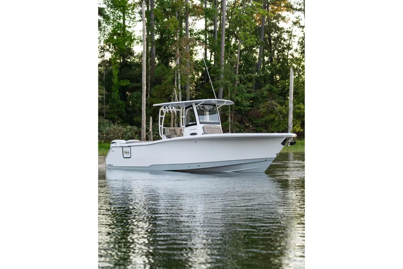 Slide: The Image of 2026 Sea Hunt Ultra 305 Coffin Box boat on calm water, surrounded by trees. - 31