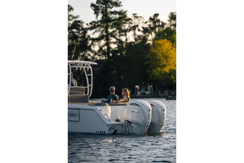 Slide: The Image of 2026 Sea Hunt Ultra 305 Coffin Box boat cruising on a serene lake at sunset. - 35