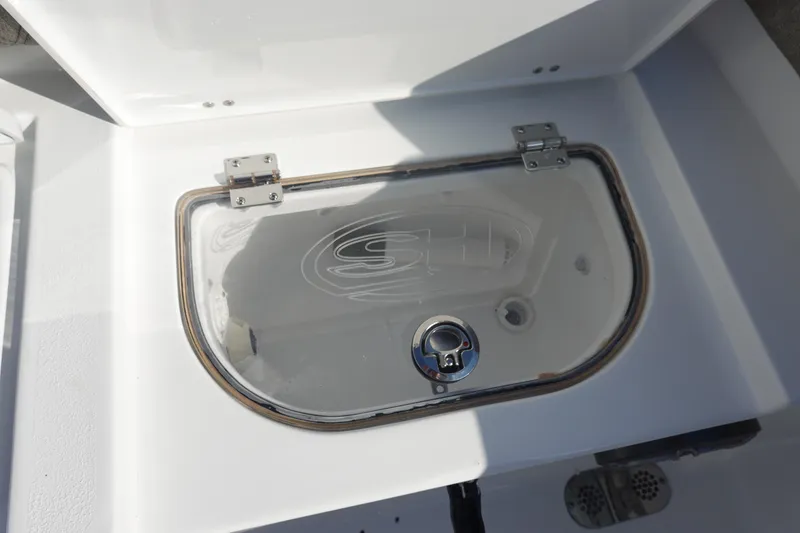 Slide: The Image of Livewell compartment on 2026 Sea Hunt Ultra 255 SE boat, featuring a clear lid and secure latch. - 13