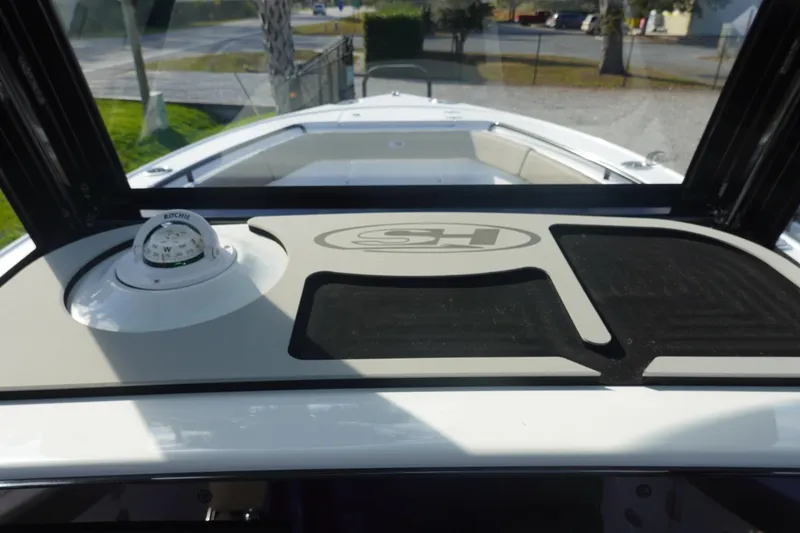 Slide: The Image of 2026 Sea Hunt Ultra 255 SE boat dashboard with compass and logo. - 27