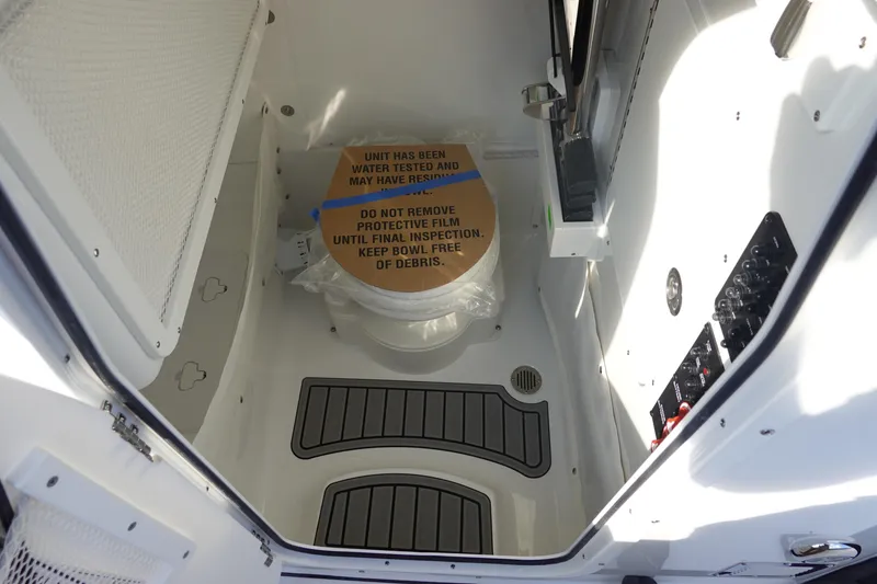 Slide: The Image of Interior of 2026 Sea Hunt Ultra 255 SE boat with protective film on toilet. - 38