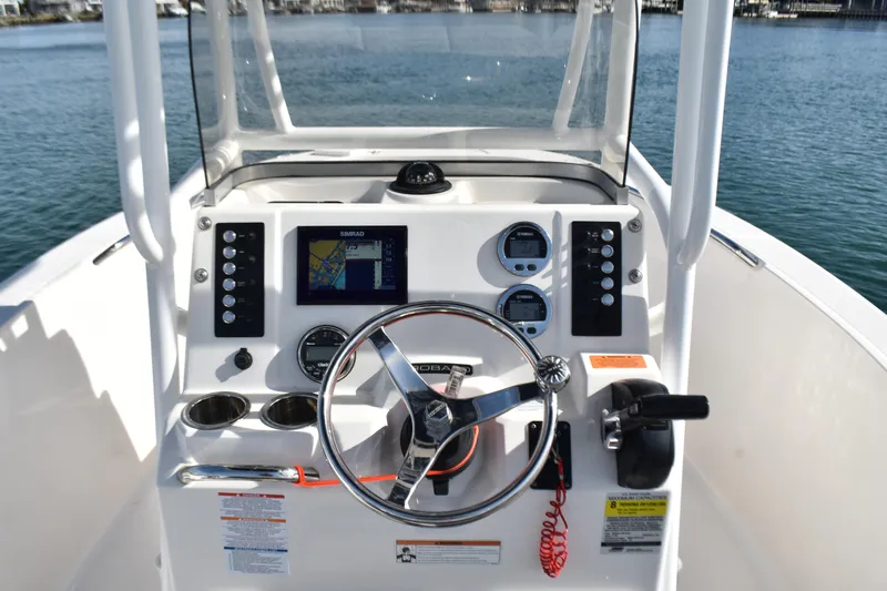 Slide: The Image of 2021 Robalo R180 Center Console boat dashboard with steering wheel and navigation system. - 9