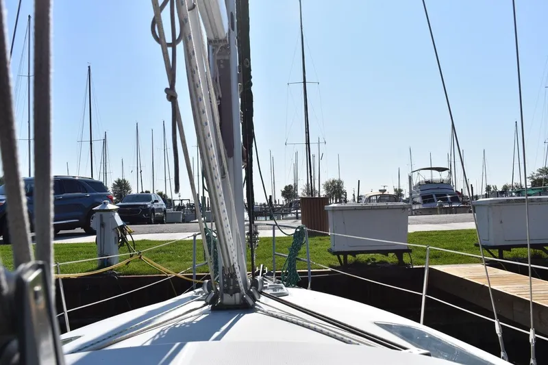Slide: The Image of Beneteau Oceanis 321 sailboat docked at marina, surrounded by parked cars and other boats. - 24