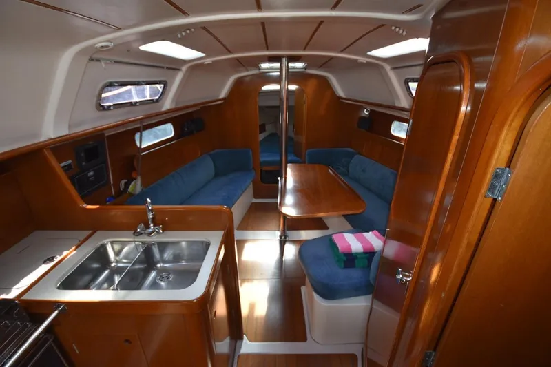 Slide: The Image of Interior of 1996 Beneteau Oceanis 321 sailboat with wood finish and blue seating. - 26