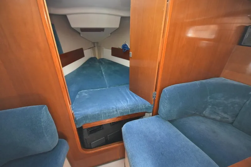Slide: The Image of Interior of 1996 Beneteau Oceanis 321 sailboat with blue upholstery and wooden finishes. - 27