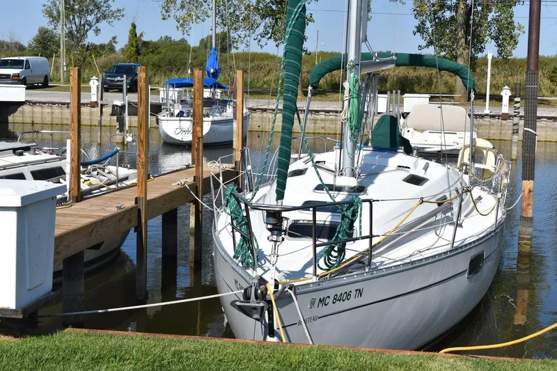 Slide: The Image of 1996 Beneteau Oceanis 321 sailboat docked at a marina with green sail cover. - 3