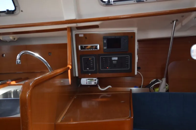Slide: The Image of Interior of 1996 Beneteau Oceanis 321 sailboat with wooden cabinetry and control panel. - 32