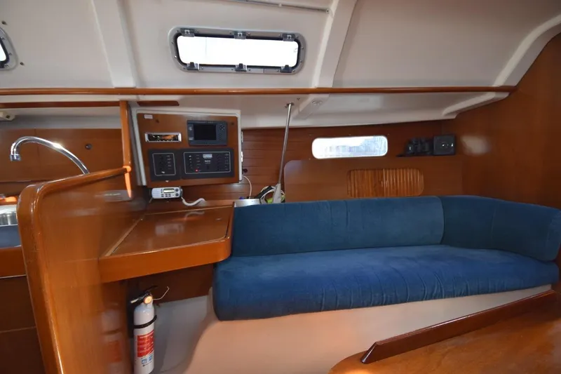 Slide: The Image of Interior of 1996 Beneteau Oceanis 321 sailboat with blue sofa and wooden cabinetry. - 33