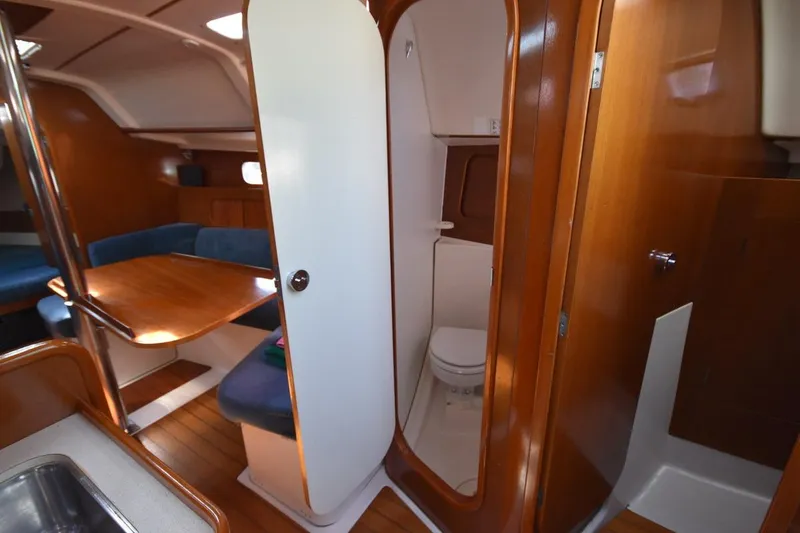 Slide: The Image of Interior of 1996 Beneteau Oceanis 321 sailboat with dining area and compact bathroom. - 37