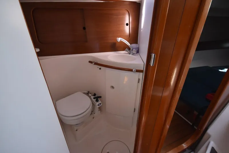 Slide: The Image of Bathroom interior of 1996 Beneteau Oceanis 321 sailboat, featuring compact toilet and sink. - 38