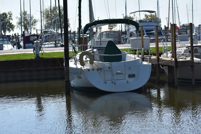 Slide: The Image of 1996 Beneteau Oceanis 321 sailboat docked in a marina, surrounded by other boats. - 4