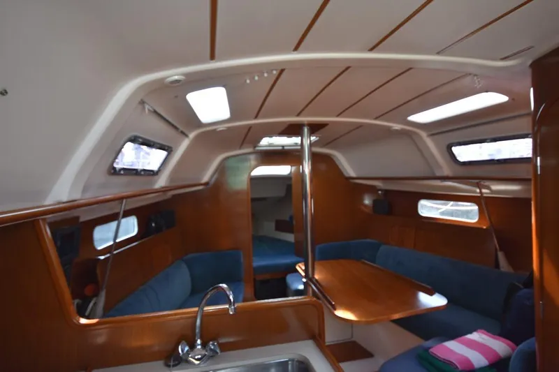 Slide: The Image of Interior of 1996 Beneteau Oceanis 321 sailboat with wooden finish and blue seating. - 42
