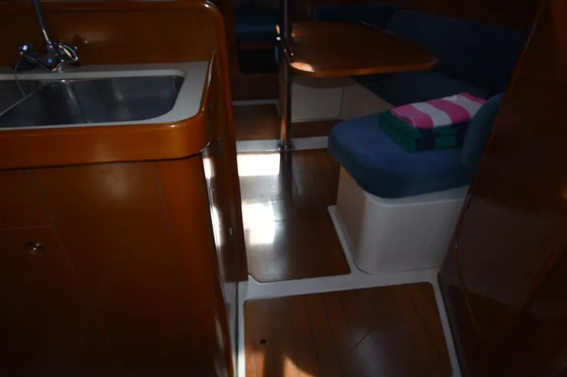 Slide: The Image of Interior of 1996 Beneteau Oceanis 321 sailboat with wooden cabinetry and seating area. - 43