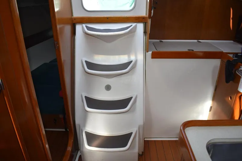 Slide: The Image of Interior view of 1996 Beneteau Oceanis 321 sailboat, featuring cabin steps and wooden finishes. - 47