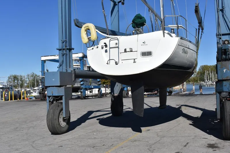 Slide: The Image of 1996 Beneteau Oceanis 321 sailboat lifted by crane at marina dock. - 48