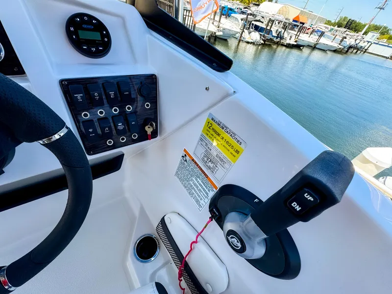 Slide: The Image of 2023 Starcraft SVX 190 OB boat dashboard with controls, docked at marina. - 10