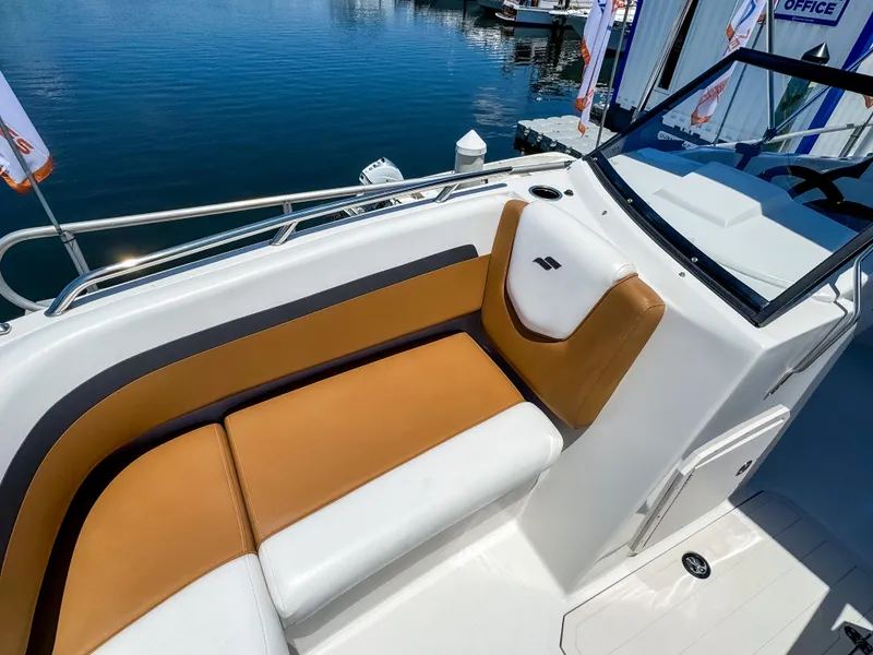 Slide: The Image of 2023 Starcraft SVX 190 OB boat interior with tan and white seating, docked by the water. - 15