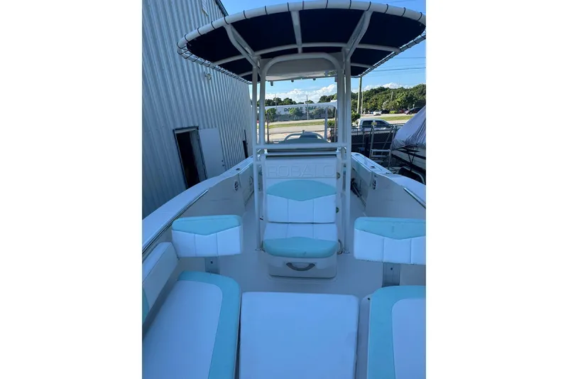 Slide: The Image of 2021 Robalo R200 Center Console boat with seating and canopy, docked outdoors. - 16
