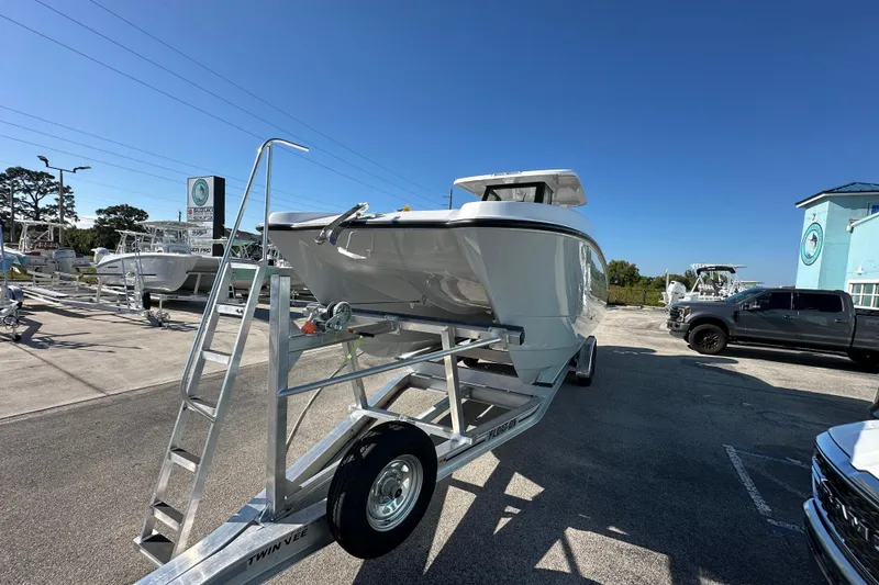 Slide: The Image of 2026 Twin Vee 280 GFX2 CC boat on trailer in dealership lot under clear blue sky. - 2