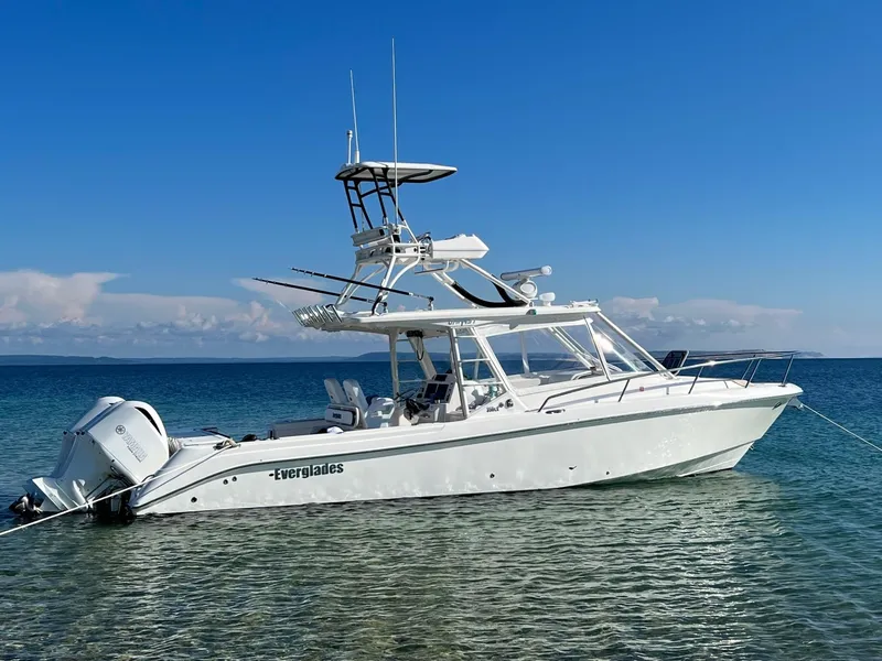 The Image of 2012 Everglades 350LX boat anchored in clear blue water under a sunny sky. - 0