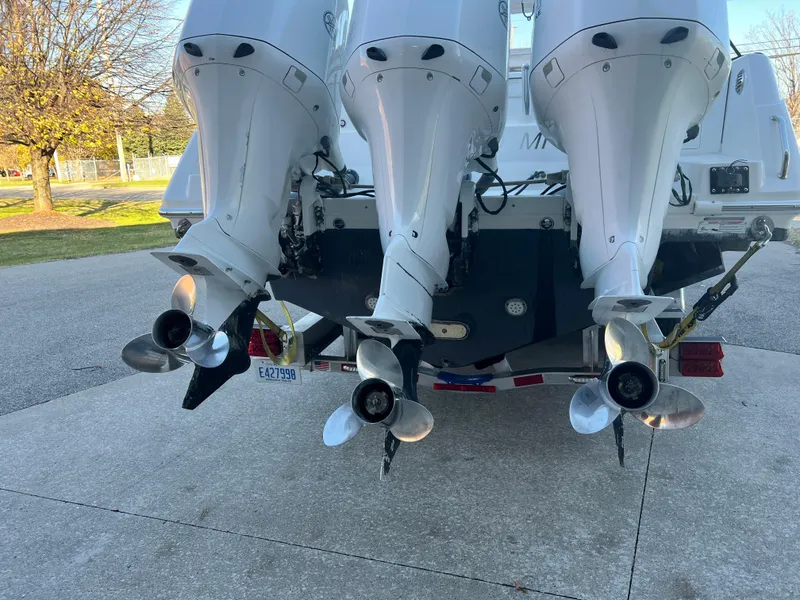 Slide: The Image of Triple outboard motors on a 2012 Everglades 350LX boat, parked on a driveway. - 19