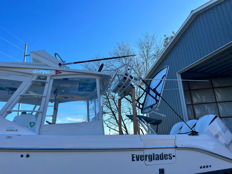 Slide: The Image of 2012 Everglades 350LX boat with dual engines, docked near a gray building under clear blue sky. - 26