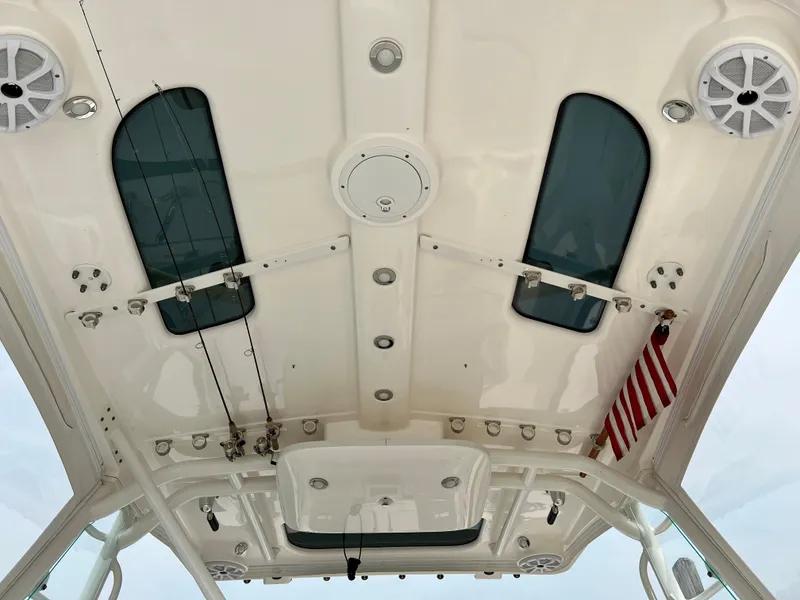 Slide: The Image of 2012 Everglades 350LX boat ceiling with speakers, rod holders, and American flag. - 27