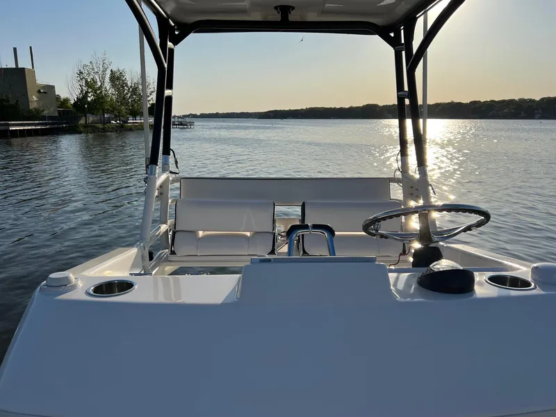 Slide: The Image of 2012 Everglades 350LX boat on calm water at sunset, featuring a sleek helm and seating area. - 29