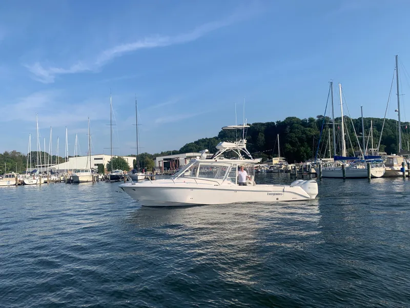 Slide: The Image of 2012 Everglades 350LX boat in a marina with sailboats and trees in the background. - 3