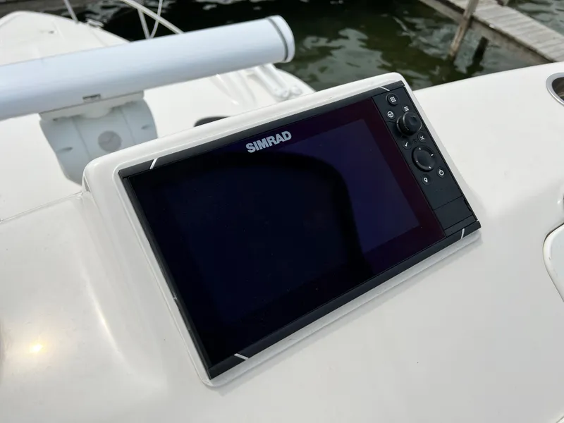 Slide: The Image of Simrad display on 2012 Everglades 350LX boat dashboard near water. - 44