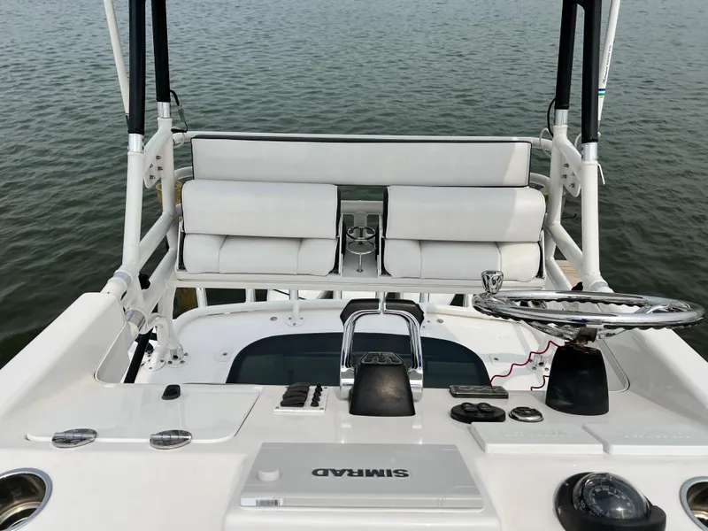 Slide: The Image of 2012 Everglades 350LX boat helm with white seating and navigation equipment on calm water. - 47