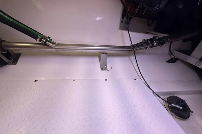 Slide: The Image of Engine compartment of a 2012 Everglades 350LX boat, showing metal pipes and wiring. - 86