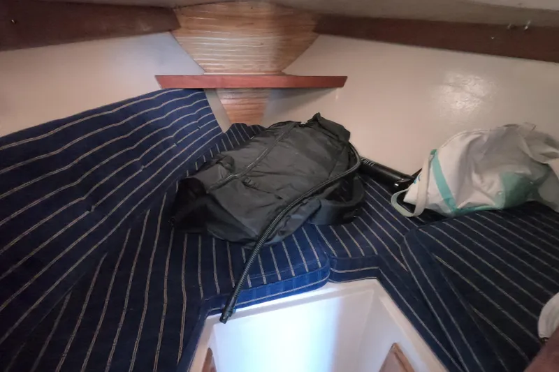 Slide: The Image of Interior of a 1986 Catalina 27 sailboat with striped cushions and bags. - 11