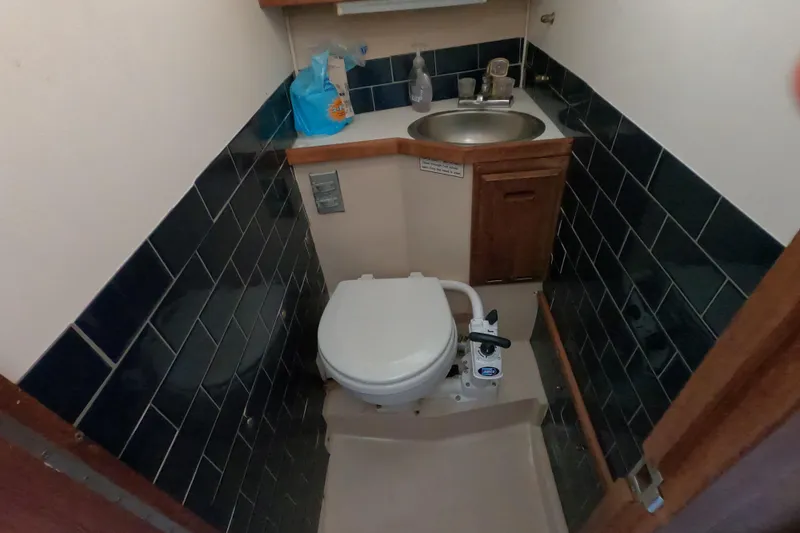 Slide: The Image of Compact bathroom in a 1986 Catalina 27 sailboat with toilet and sink. - 12