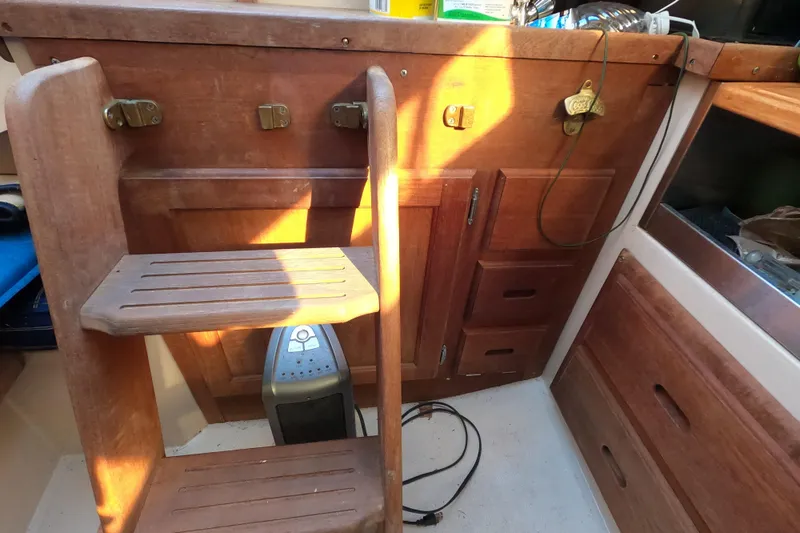 Slide: The Image of Interior of 1986 Catalina 27 sailboat with wooden steps and storage compartments. - 13