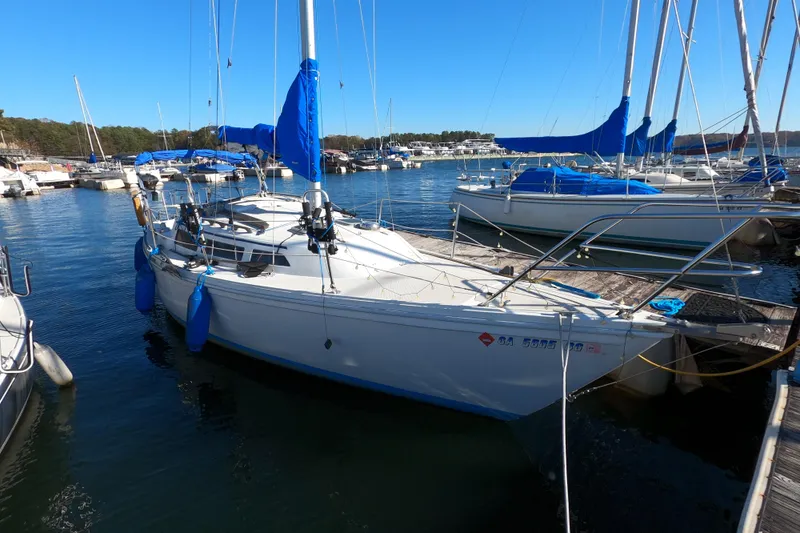 Slide: The Image of 1986 Catalina 27 sailboat docked at marina with blue covers and clear sky. - 2