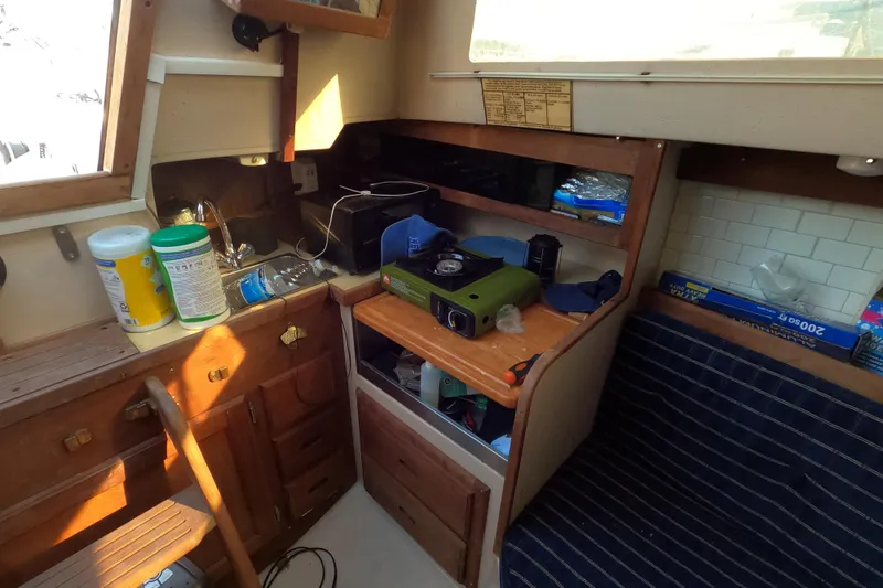 Slide: The Image of Interior of a 1986 Catalina 27 sailboat with compact kitchen setup. - 7