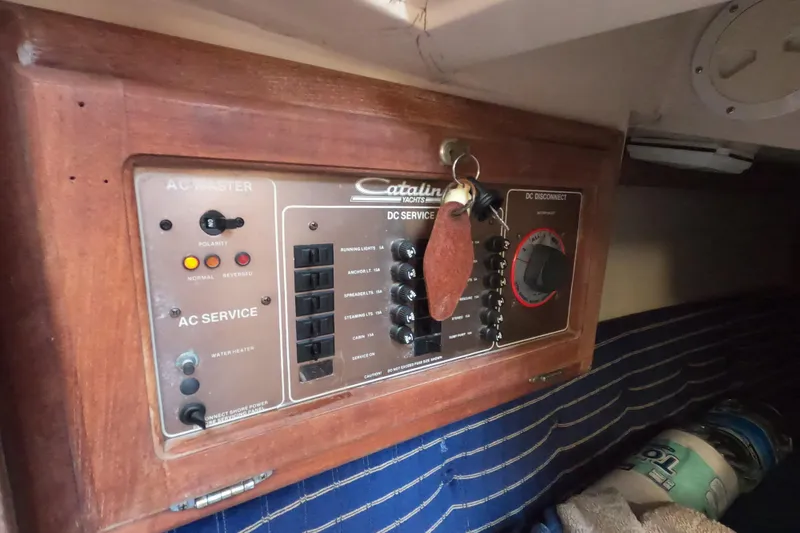 Slide: The Image of Electrical panel of a 1986 Catalina 27 yacht with AC and DC service controls. - 9